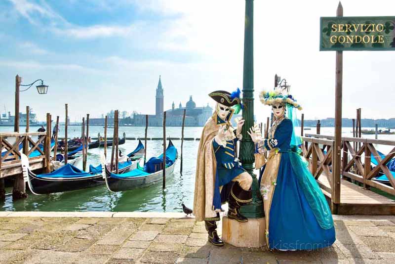 man and woman wearing carnival masks and costumes in venice best things to do in italy in winter
